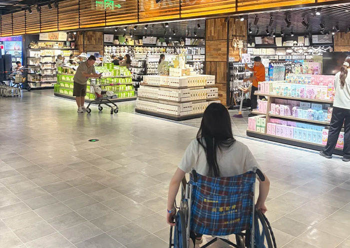 Persona en silla de ruedas comprando en un centro comercial accesible