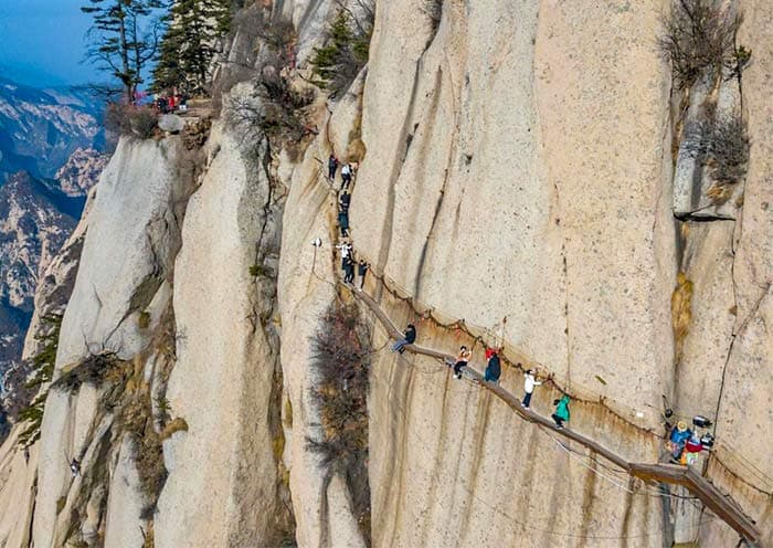 Walking on narrow planks bolted onto the side of a cliff